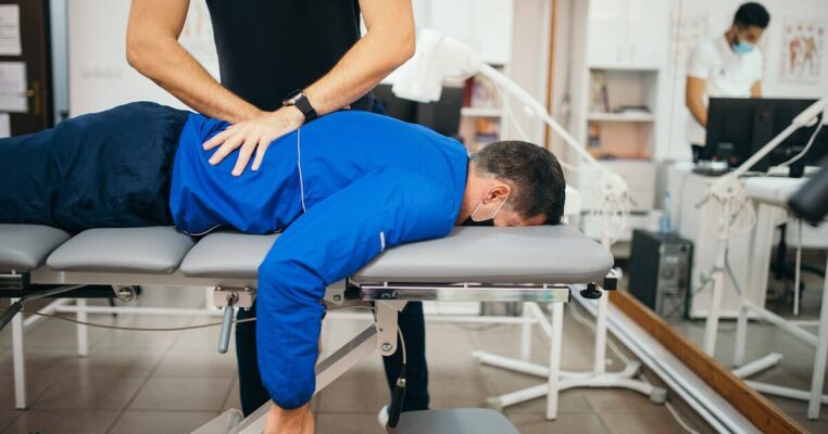 Chiropractor performing a gentle lower back adjustment on a patient